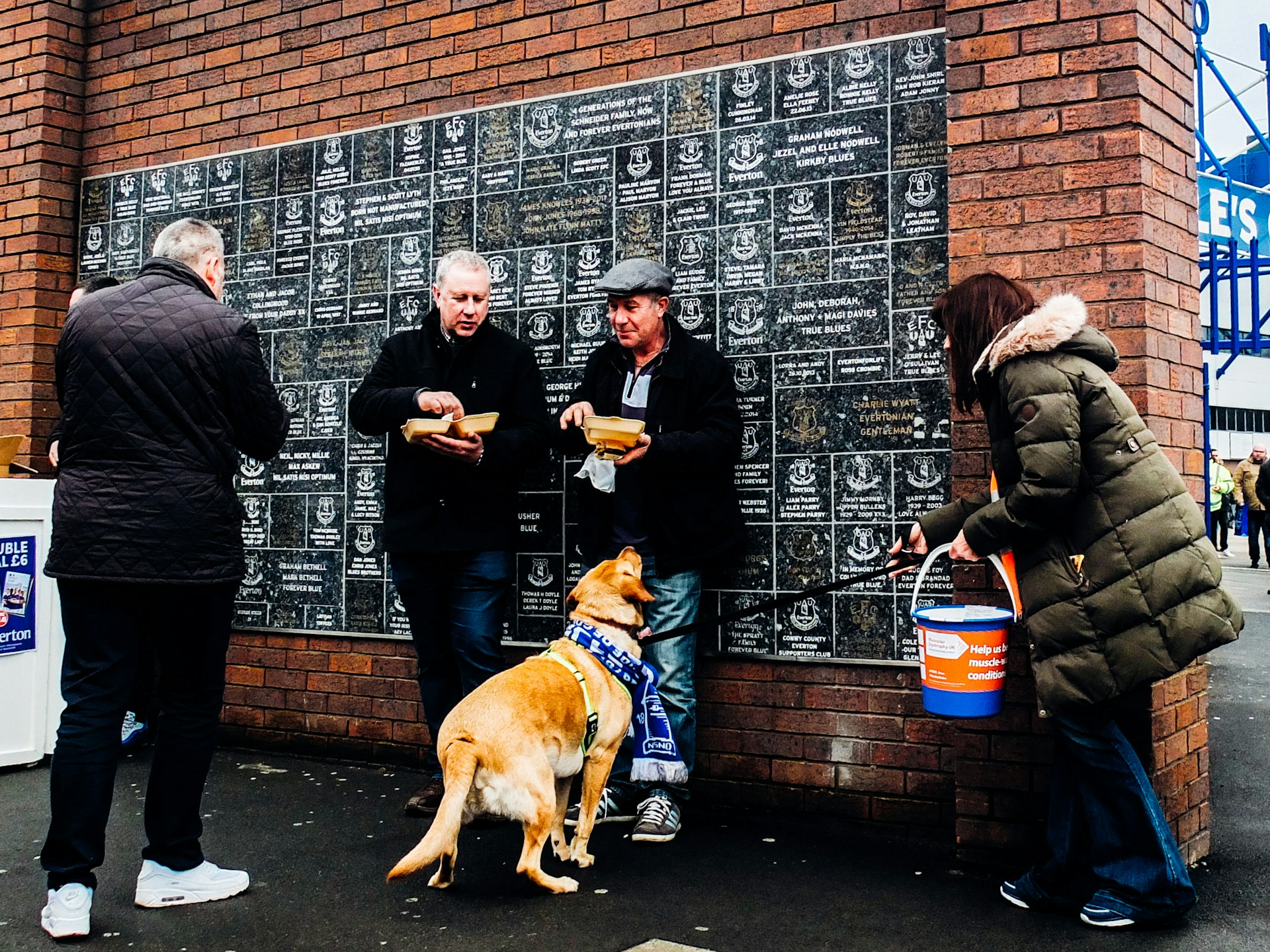 A picture of Everton fans outside a memorial wall at Goodison Park.