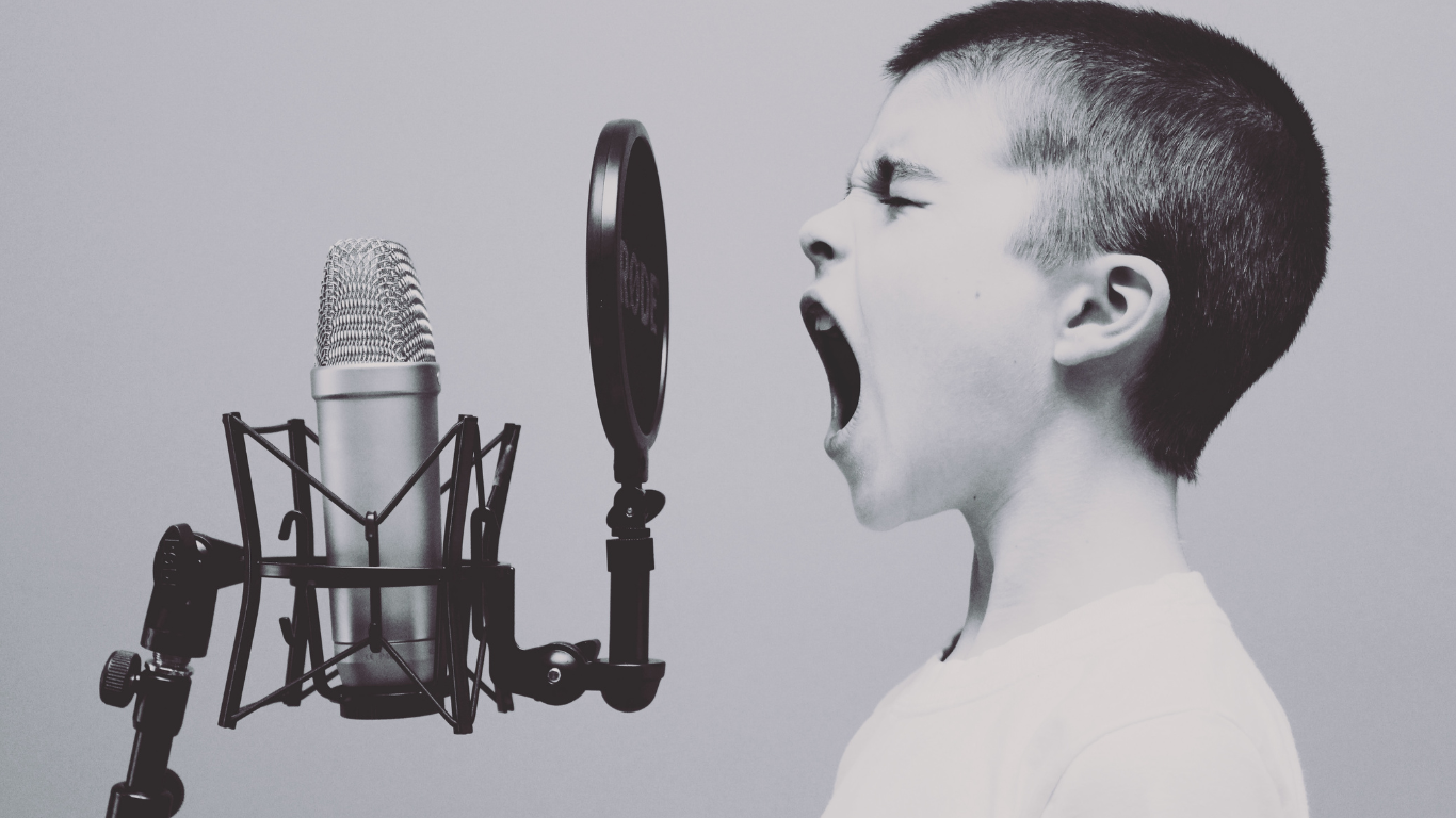 Boy shouting into microphone.