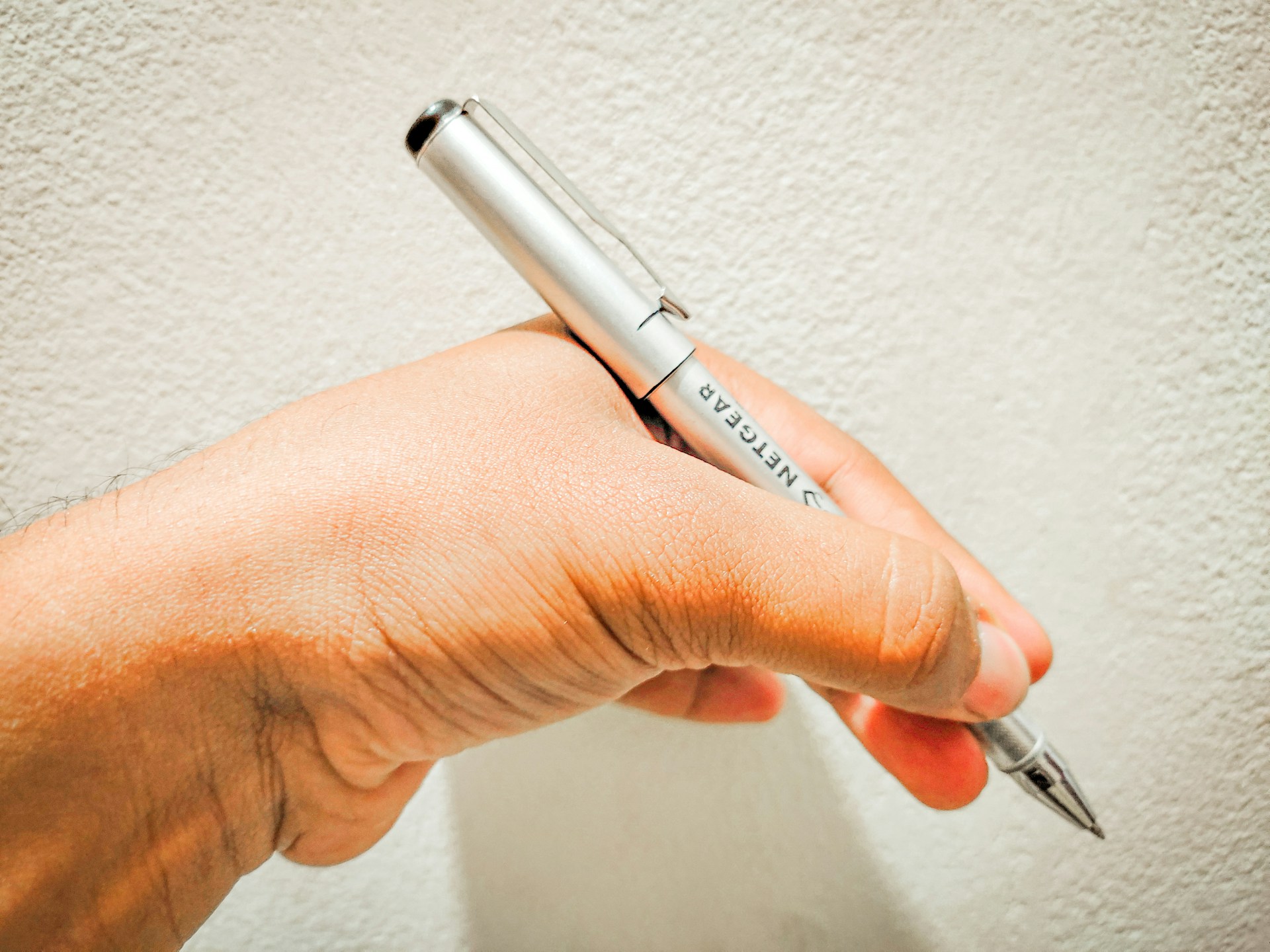 Left-handed person holding a pen.